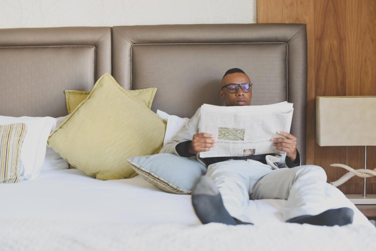 Menlyn Boutique Hotel Pretoria-Noord Extérieur photo A man reading a newspaper