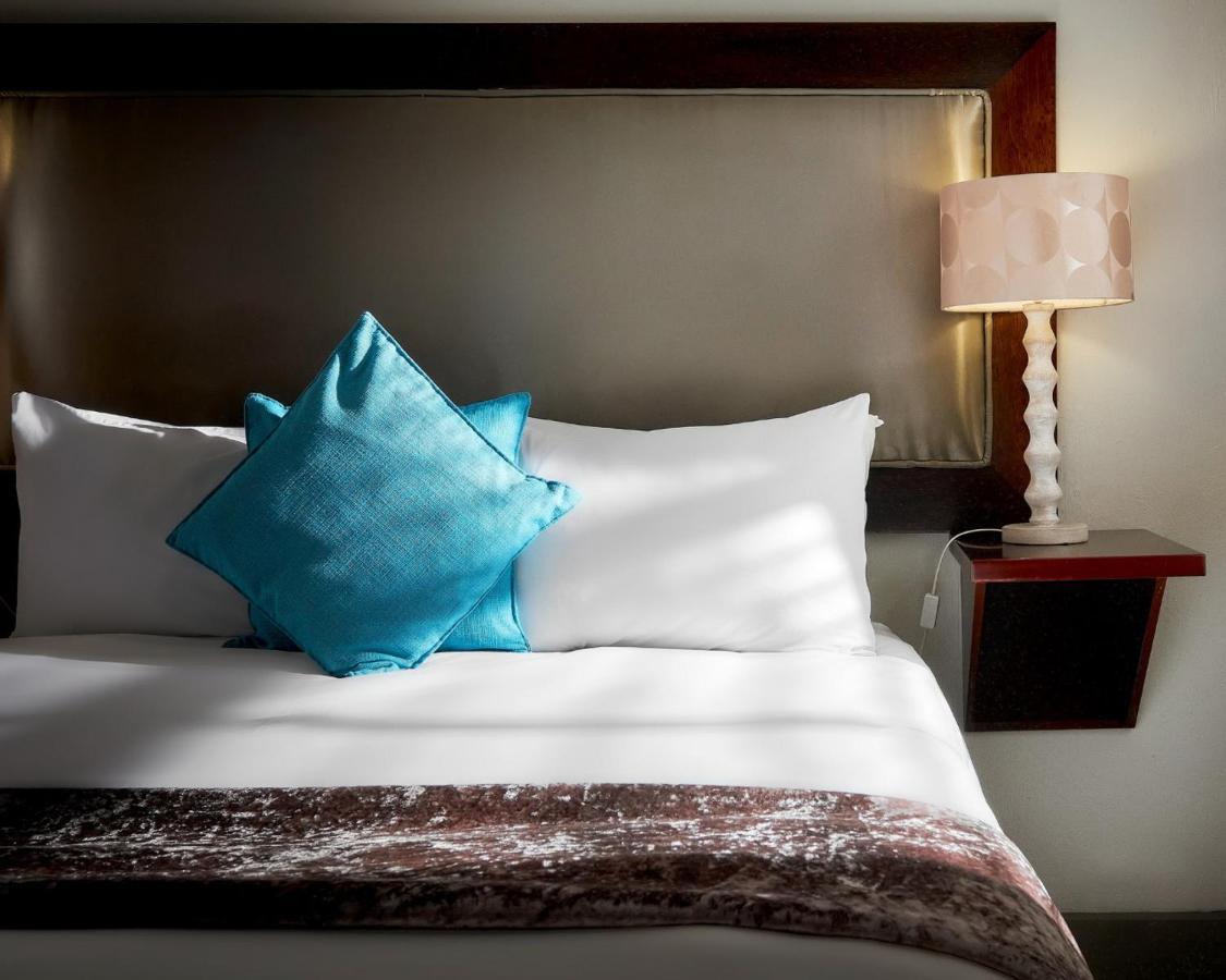 Menlyn Boutique Hotel Pretoria-Noord Extérieur photo A bed with a blue throw pillow